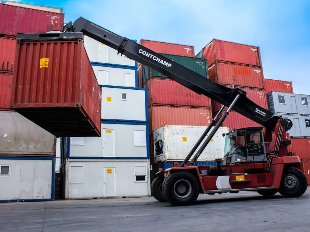 Grúa reachstacker moviendo un container — logística propia